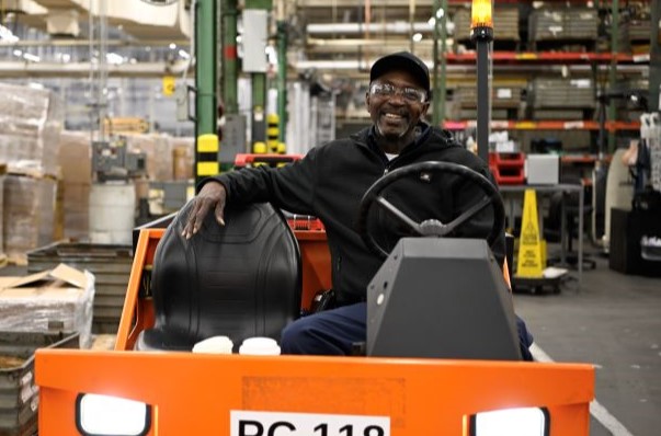 An S&C team member smiles while operating a machine handling truck An S&C team member smiles while operating a machine handling truck