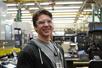 An S&C team member smiles while assembling an S&C product An S&C team member smiles while assembling an S&C product