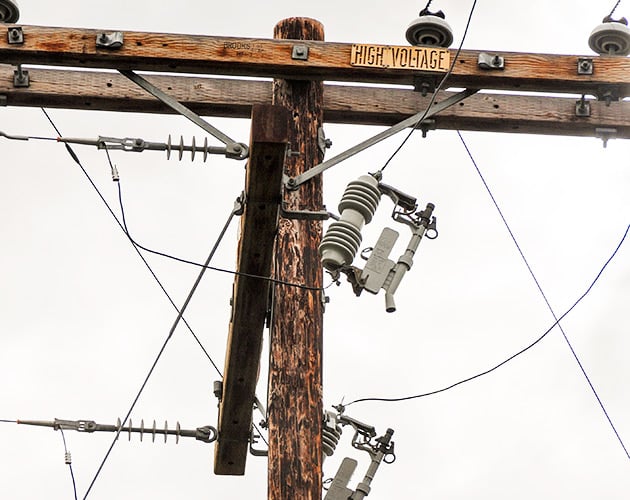 Installed Fault Tamer Fuse Limiter on a wooden pole conventional fuse cutout and a backup current-limiting fuse,